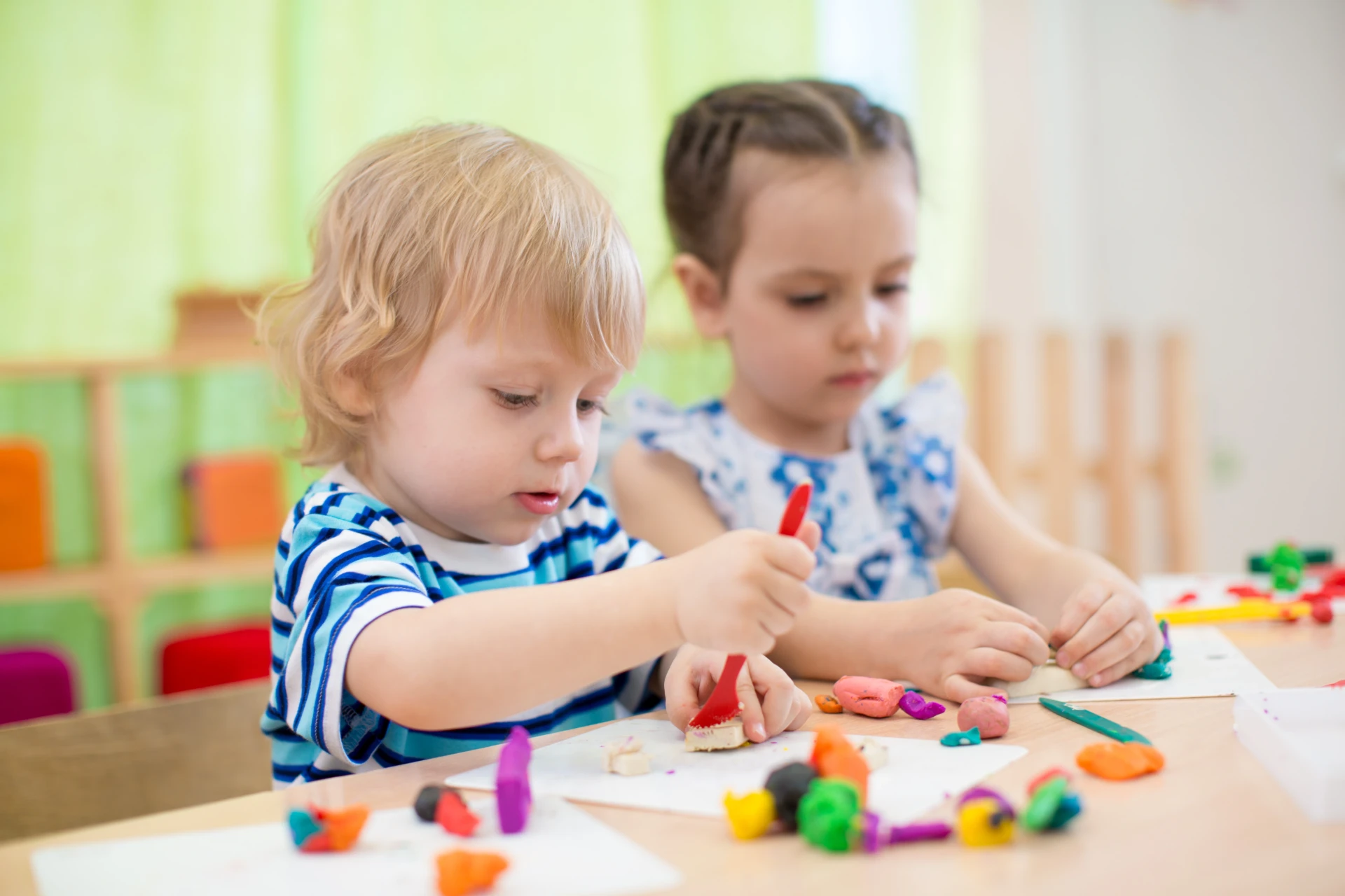 Two young children shaping colorful modeling clay