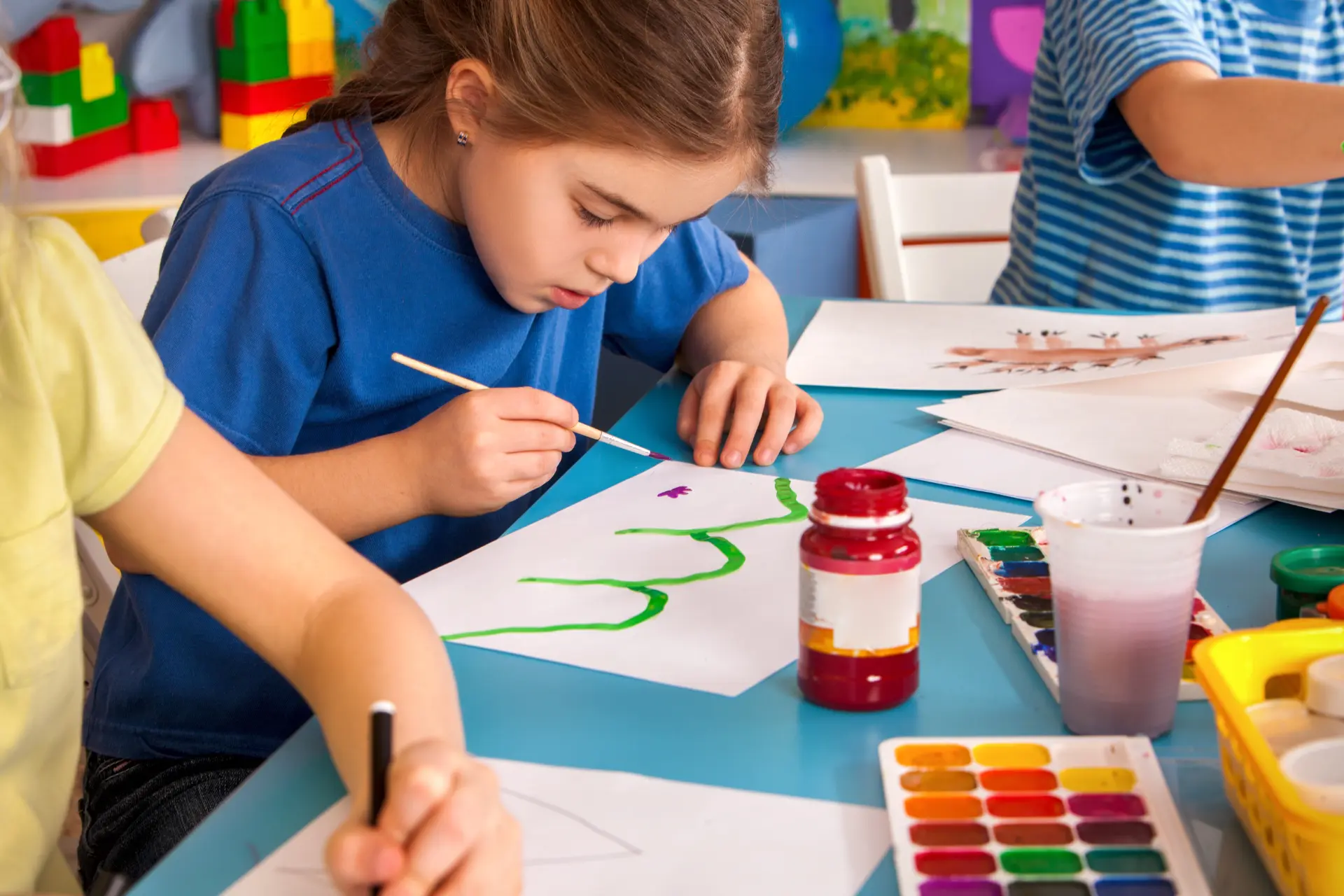 A school-age child concentrating on a colorful painting